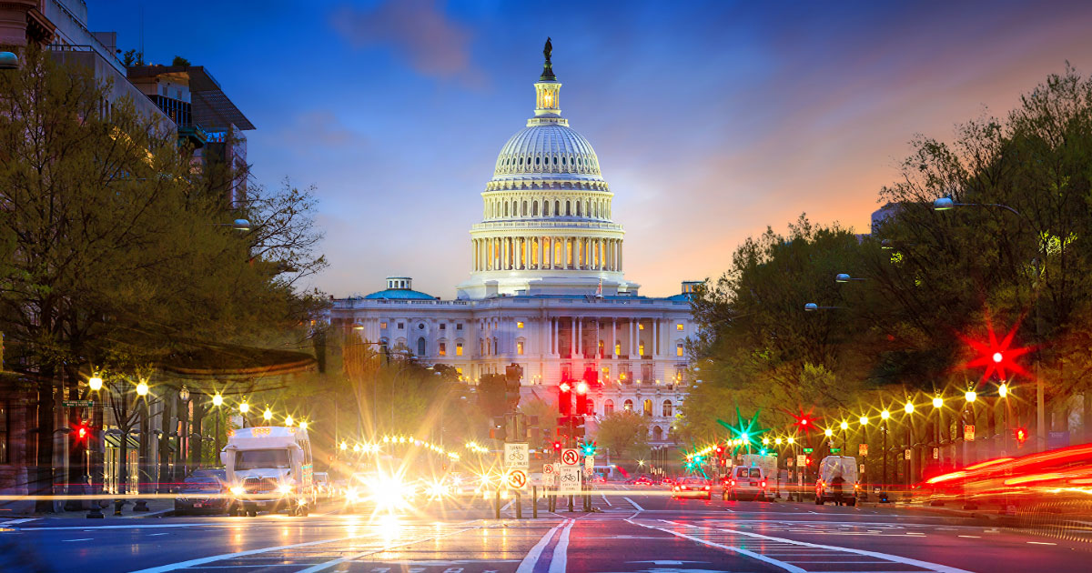 Photo of the U.S. Capitol Building in Washington, D.C., at night, showing blurred car and street lights and the illuminated dome.